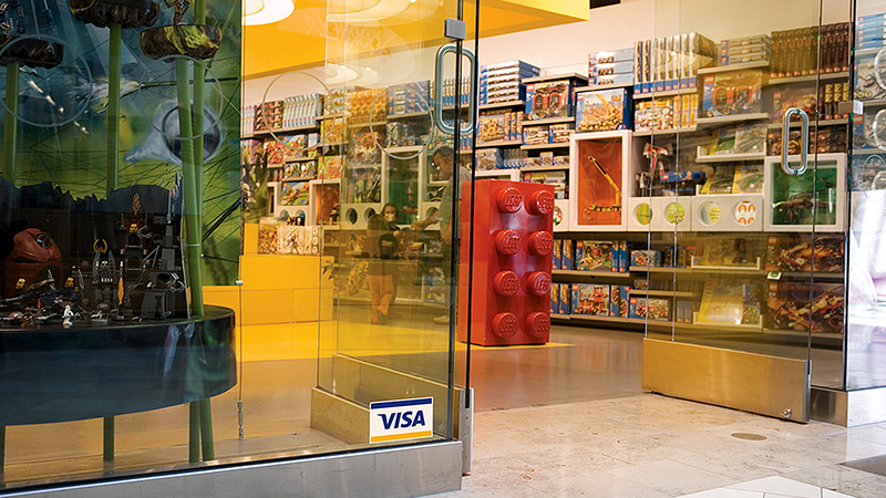 A toy store retailer with the Visa logo displayed at the entrance.