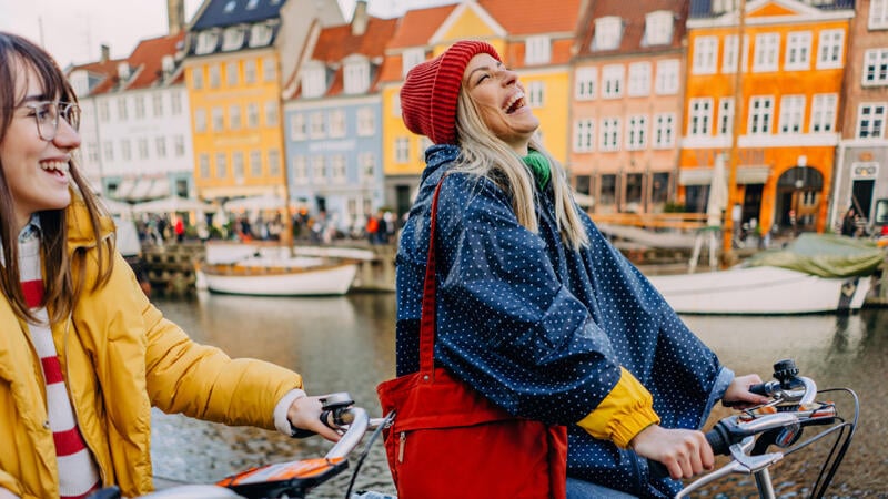Two women laughing on a bicycle